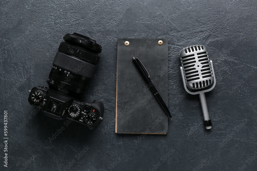 Notebook with photo camera and microphone on dark background