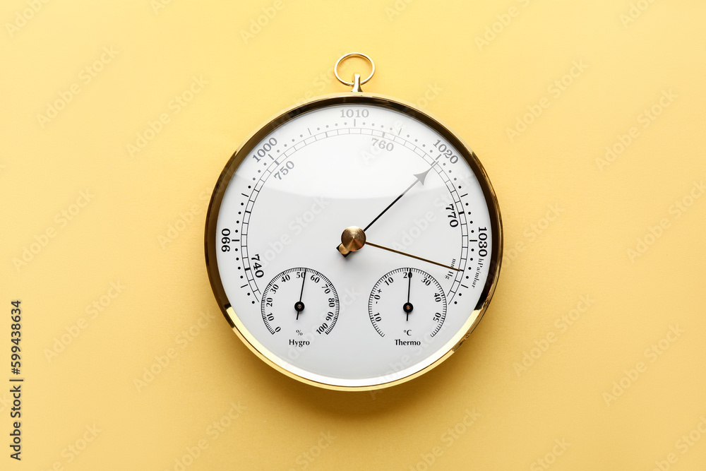 Aneroid barometer on yellow background