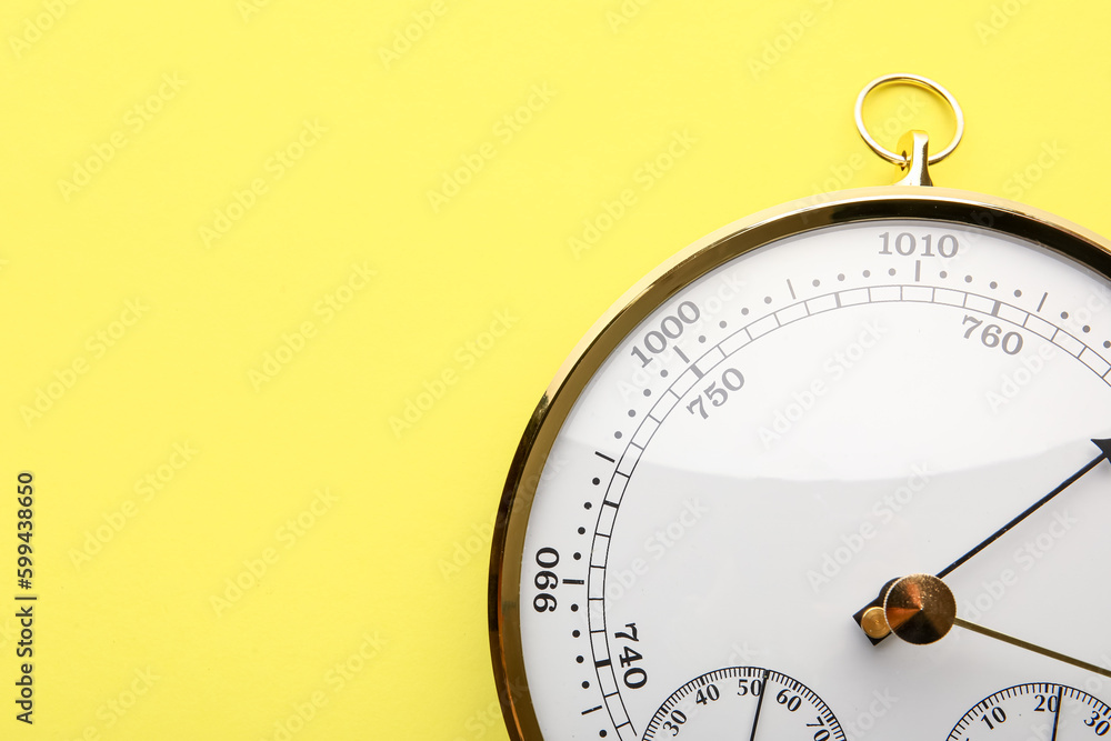 Aneroid barometer on yellow background