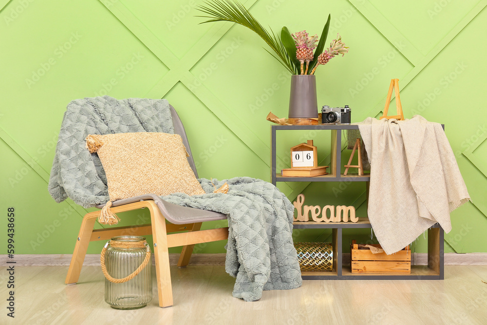 Interior of living room with chair, shelving unit and stylish decor