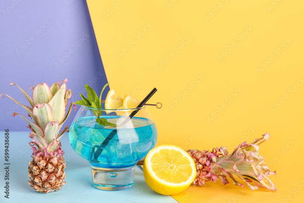 Glass of cocktail with lemon and baby pineapples on table