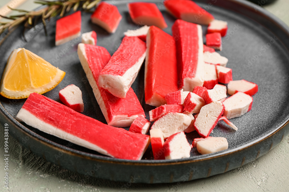 Plate with tasty crab sticks on light background, closeup