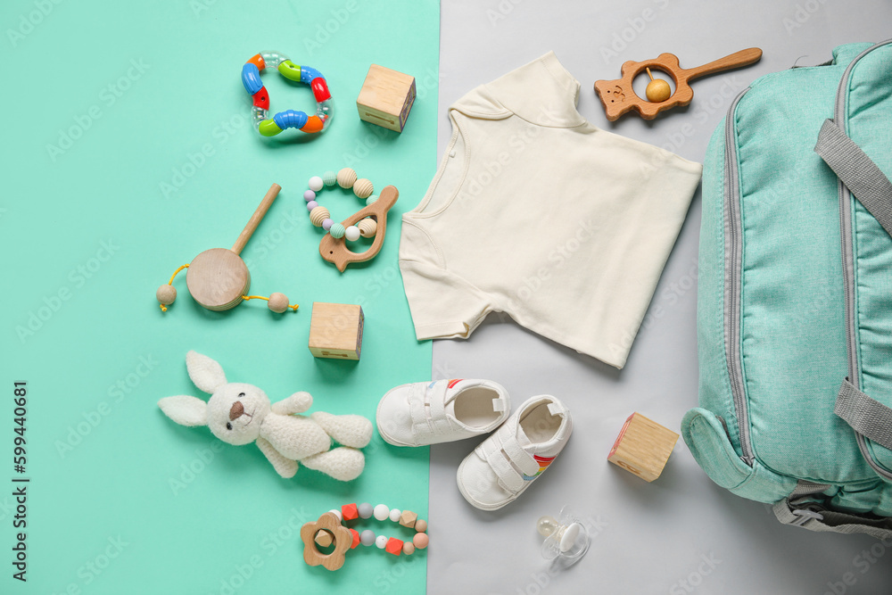 Composition with baby clothes and toys on turquoise background