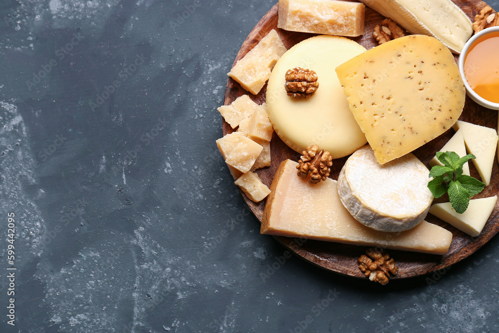 Plate with different types of cheese on blue background