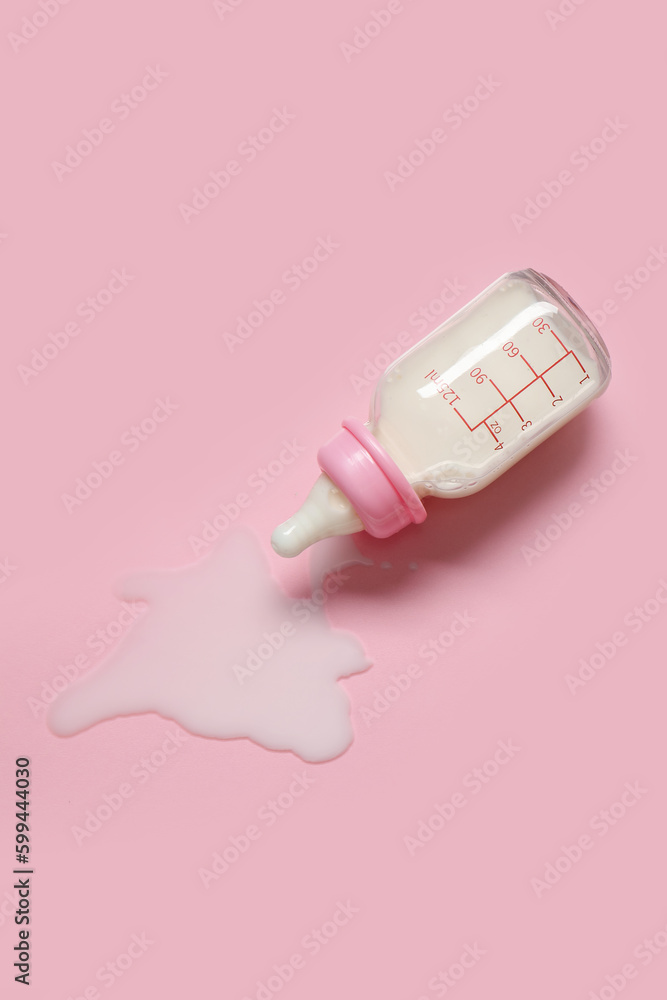 Bottle of milk for baby on pale pink background