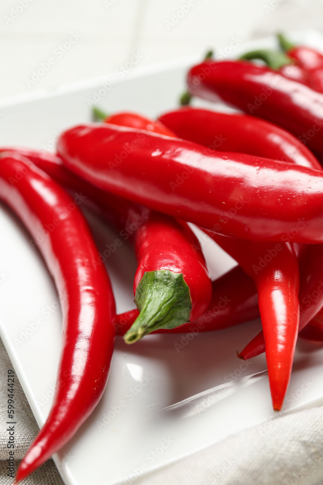 Plate with fresh chili peppers on table, closeup