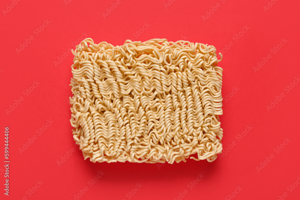 Raw instant noodles on red background