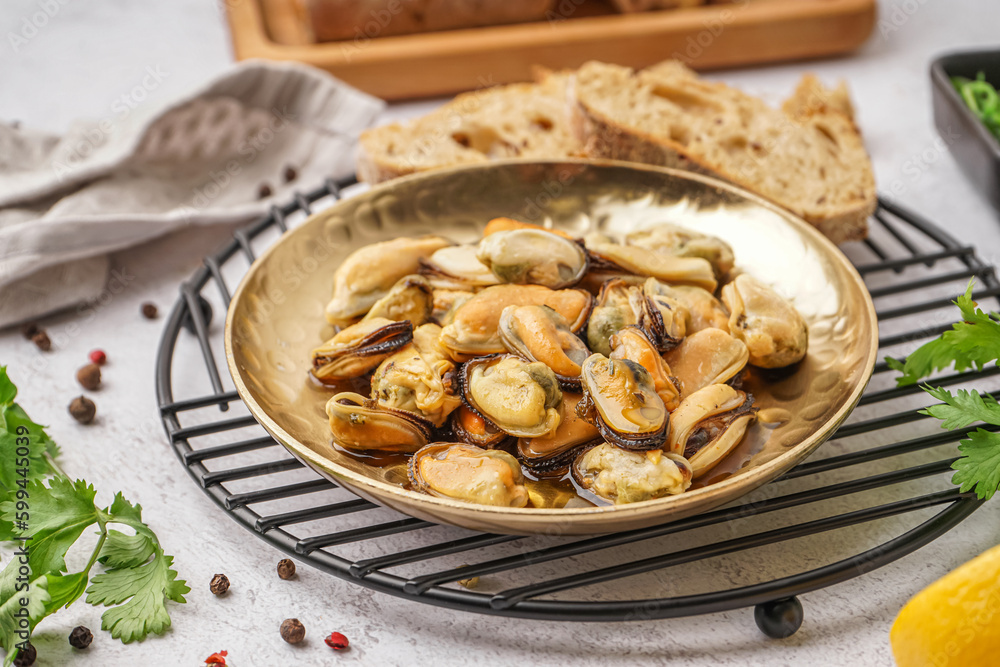 Plate of pickled mussels on grey background