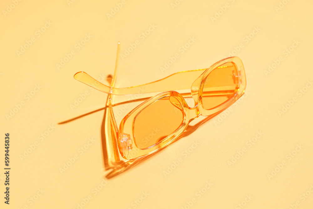 Modern sunglasses on orange background