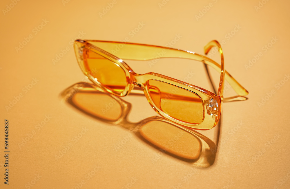 Modern sunglasses on orange background