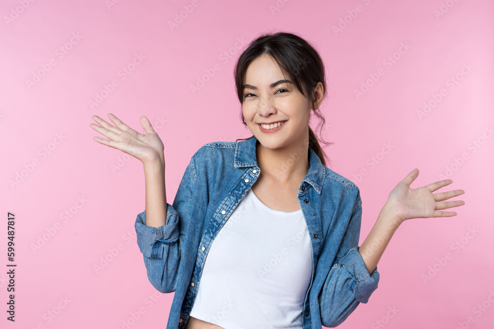 Young woman with surprise facial expression gesture with open palms over isolated pink background