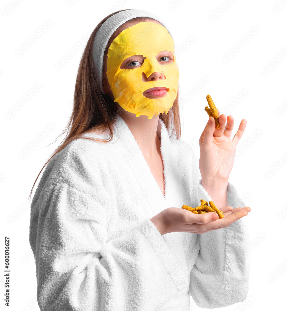 Young woman with turmeric mask and roots on white background