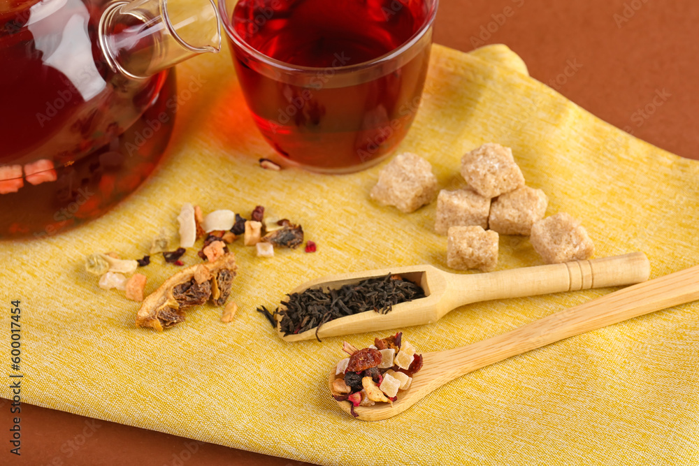 Wooden spoon and scoop with dried fruit tea on napkin, closeup