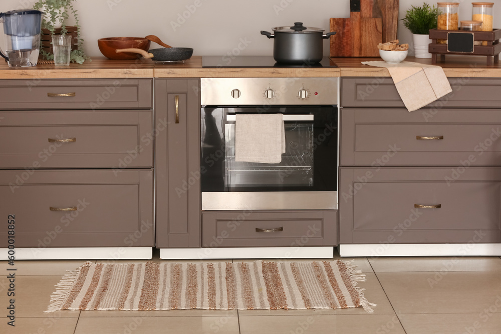 Stylish rug on floor in kitchen