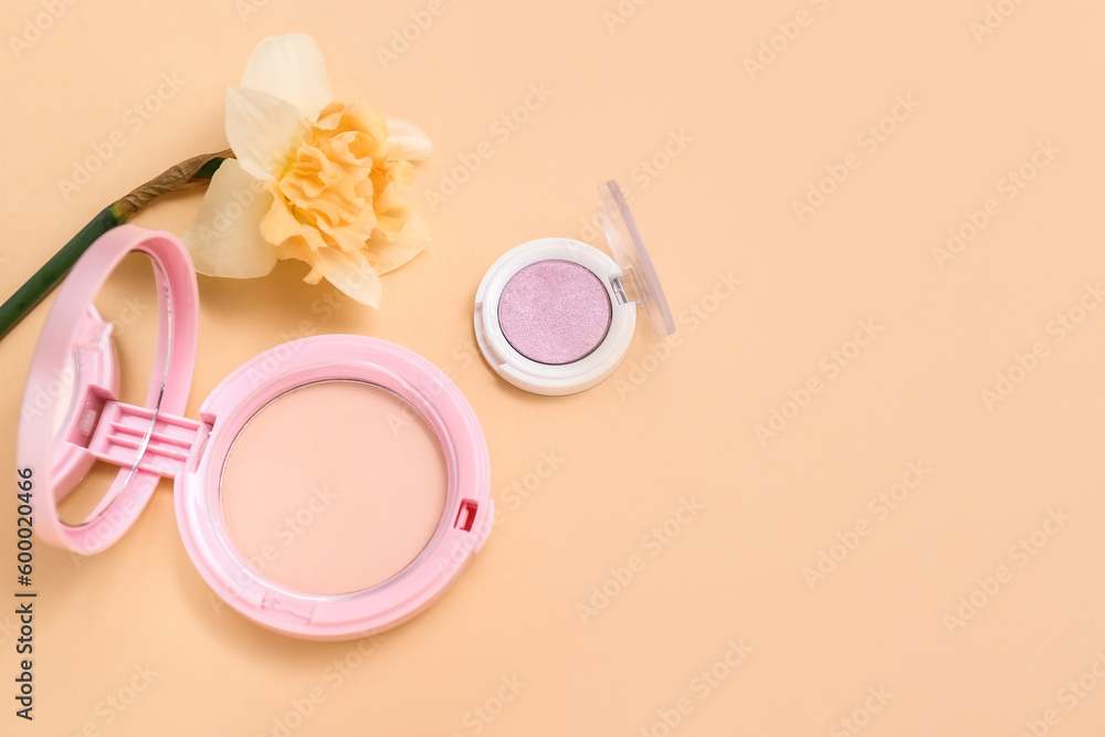 Beautiful daffodil with different cosmetics on pale orange background