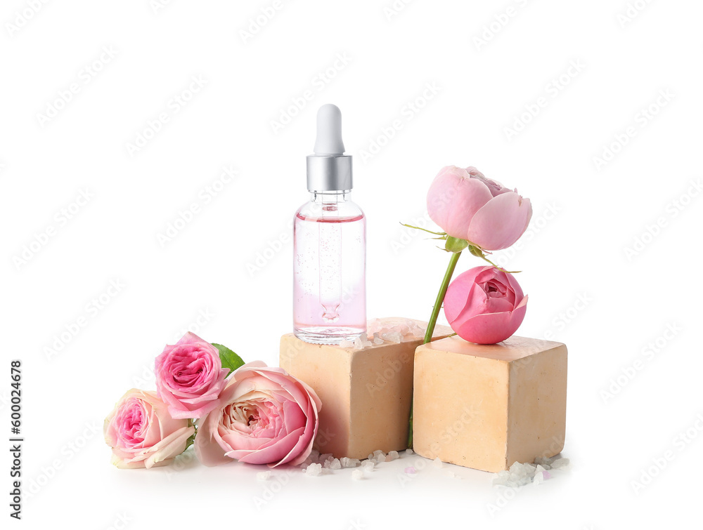 Bottle of cosmetic oil with rose extract and flowers on white background