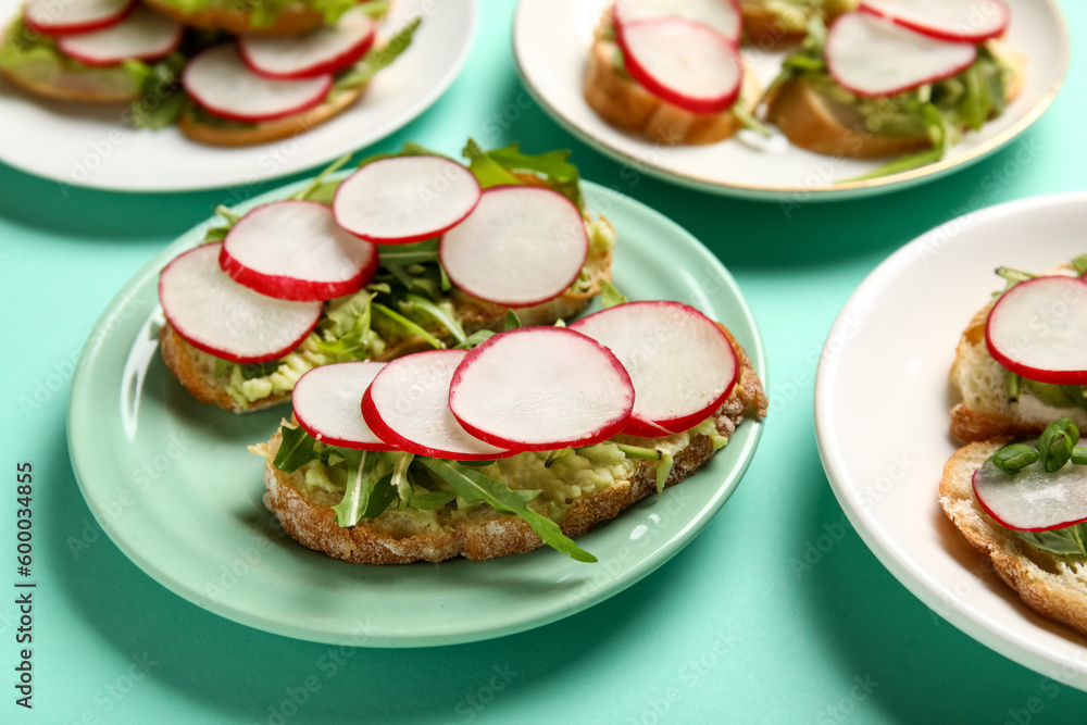 Plates with delicious radish bruschettas on turquoise background