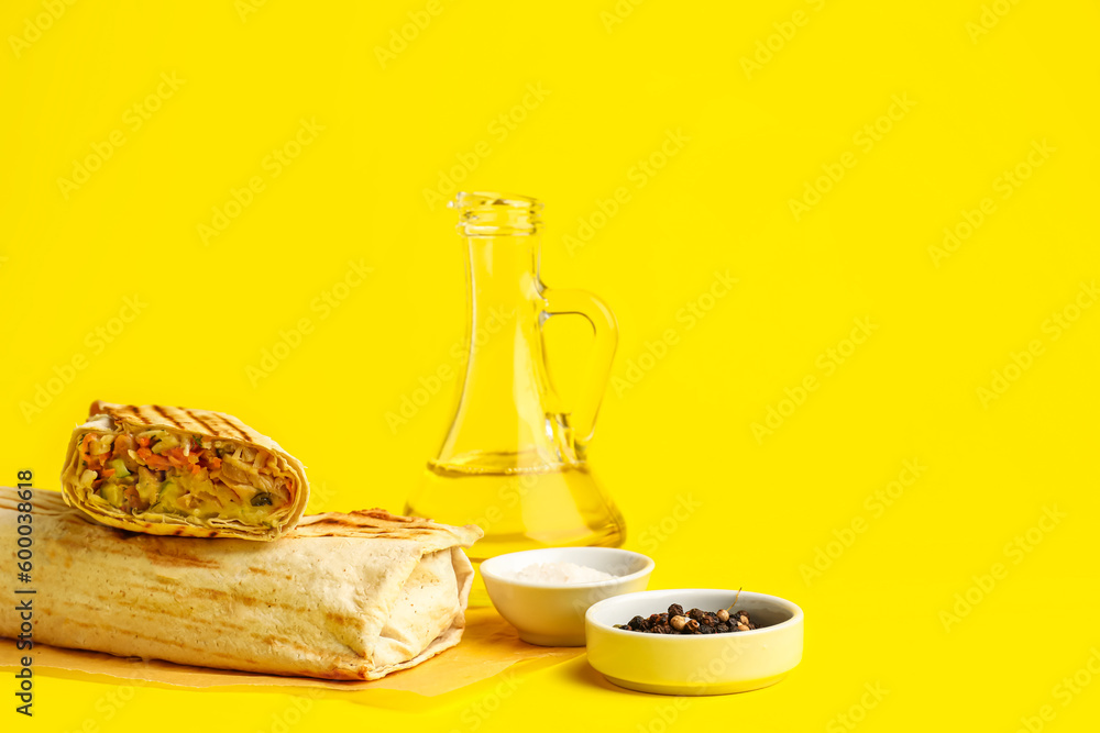 Baking paper with tasty shawarma on yellow background