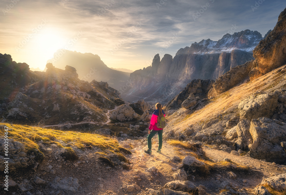 Girl with backpack on the trail in mountain canyon at sunset in autumn. Beautiful landscape with you