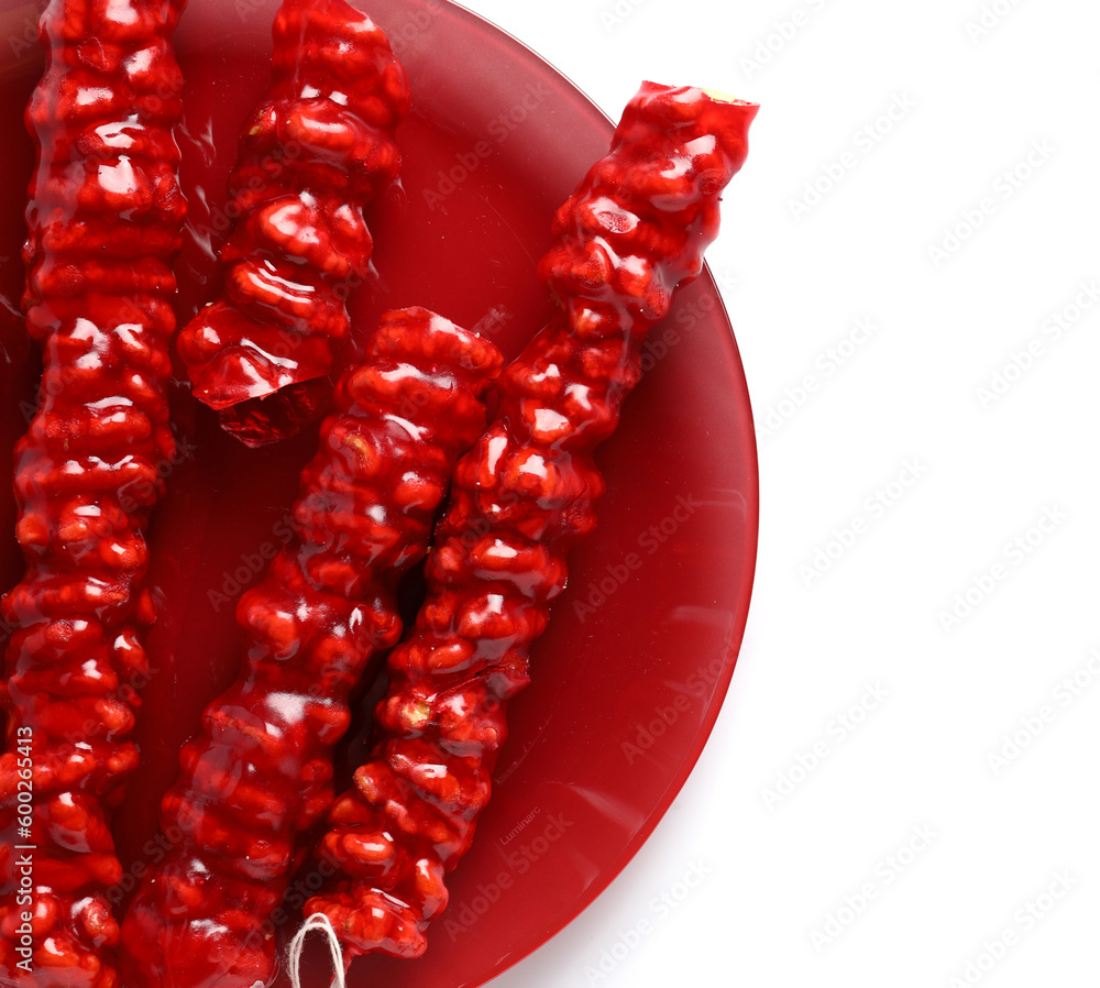 Plate with tasty churchkhela on white background, closeup