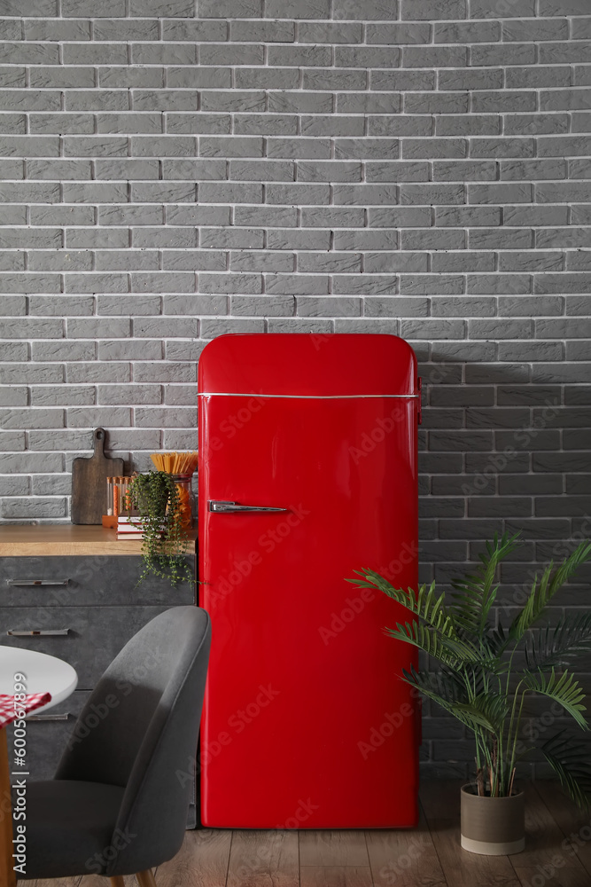 Stylish refrigerator in interior of modern kitchen