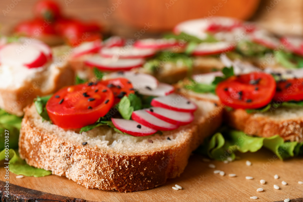 Board with delicious radish bruschettas, closeup