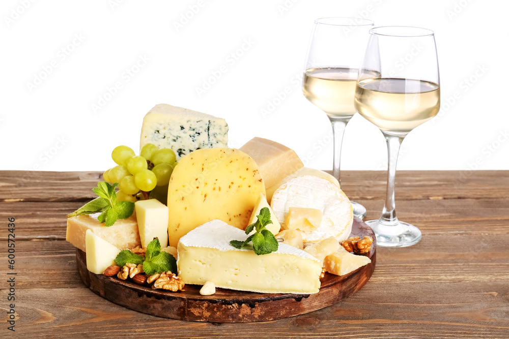 Different types of tasty cheese and glasses with wine on table against white background