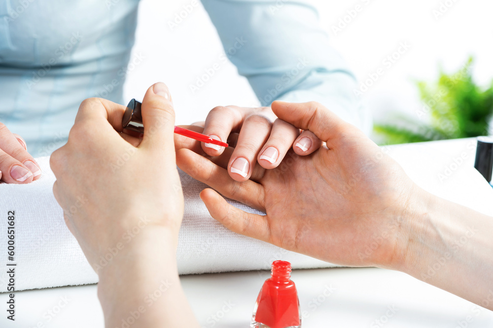 Manicurist working with clients nails at table