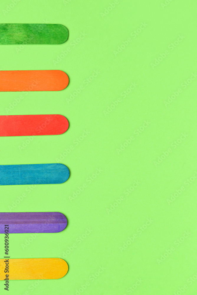 Colorful ice cream sticks on green background