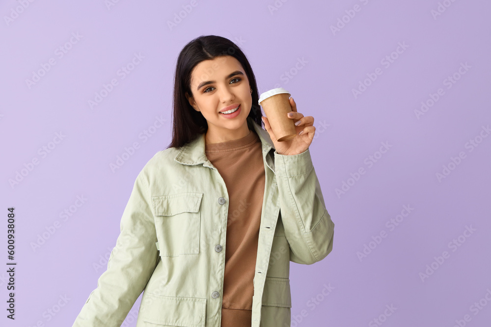 Pretty young woman drinking coffee on lilac background