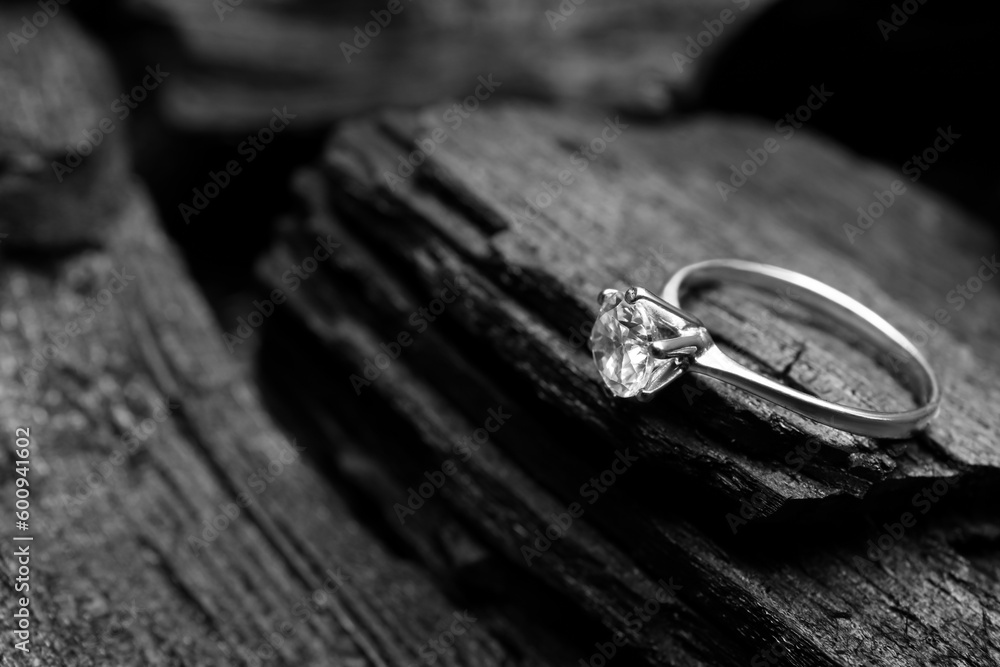 Silver ring on black charcoal, closeup