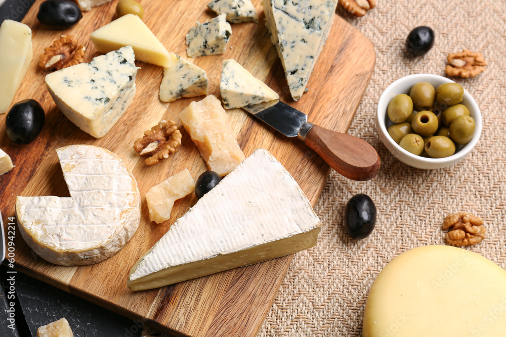 Wooden board with different types of tasty cheese on table