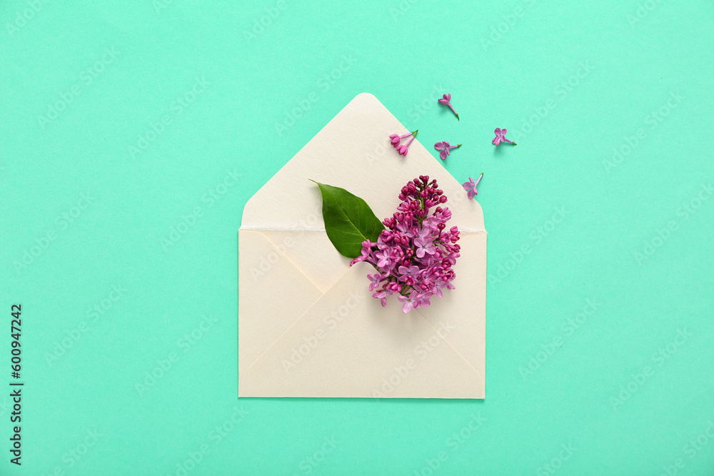 Envelope and lilac flowers on turquoise background