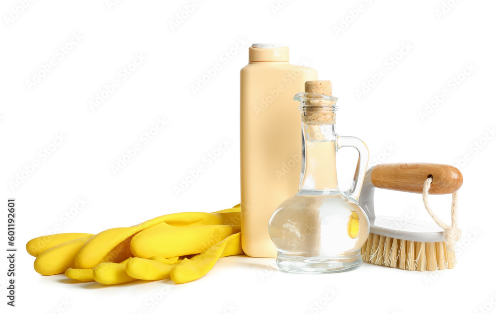 Decanter of vinegar, detergent, brush and rubber gloves on white background