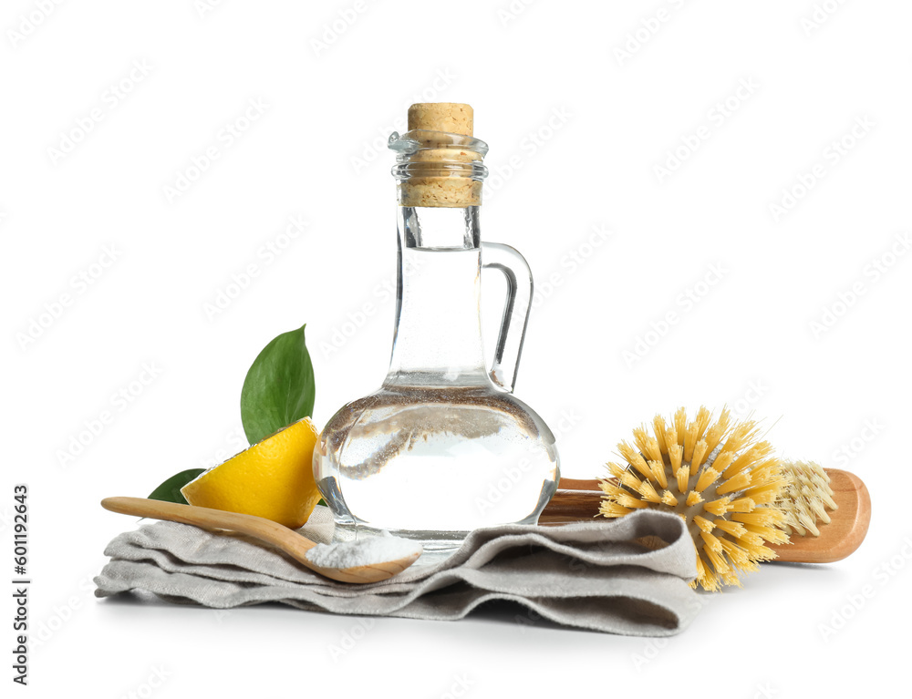 Jug of vinegar, brushes, baking soda and napkin on white background