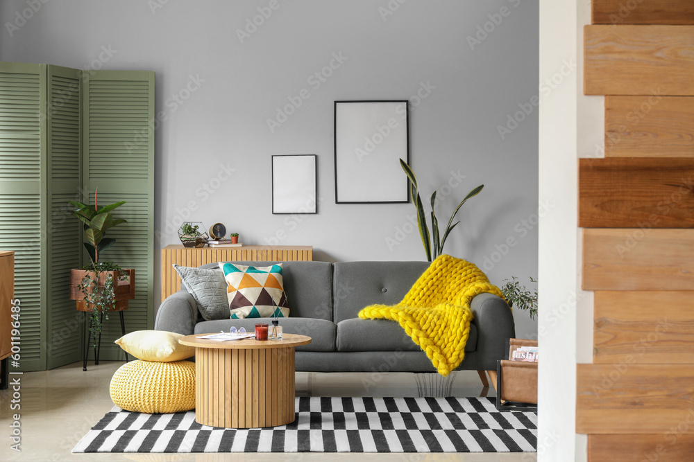 Interior of stylish living room with cozy sofa and coffee table, view through doorway