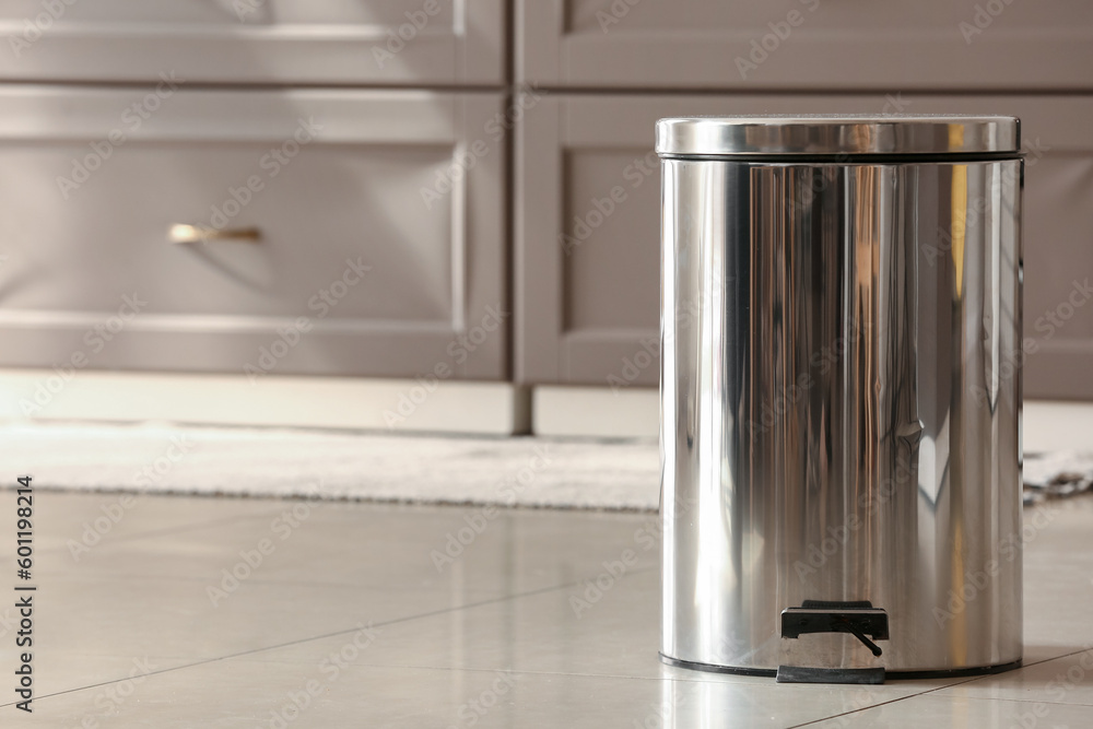 Metallic trash bin on floor in modern kitchen