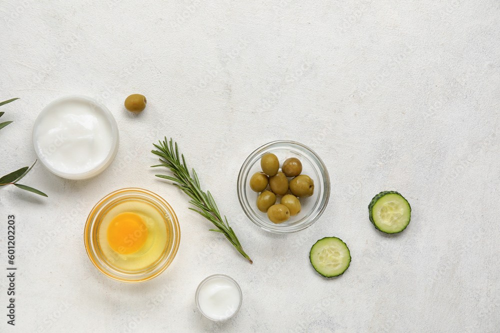 Composition with jars of cream and natural ingredients on light background