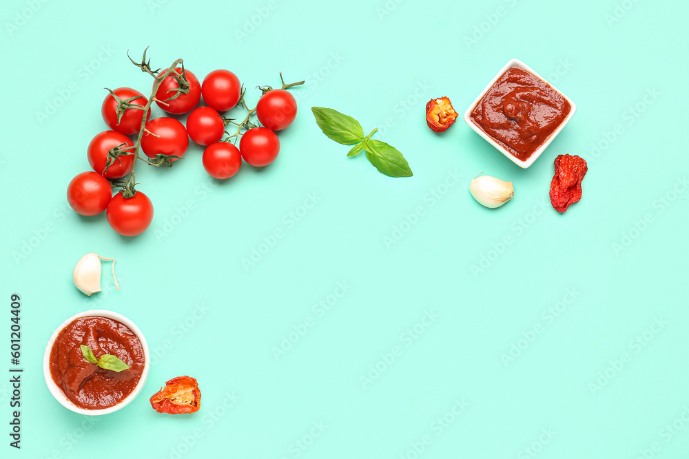 Bowls of delicious tomato sauce and ingredients on turquoise background