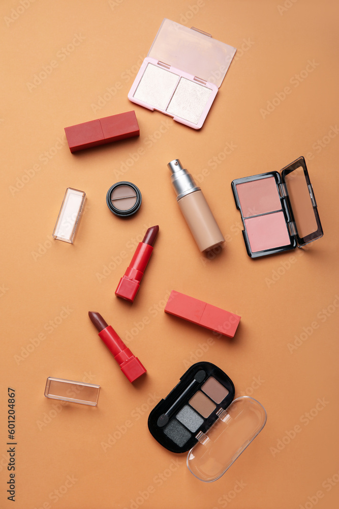 Decorative cosmetics with lipsticks on beige background