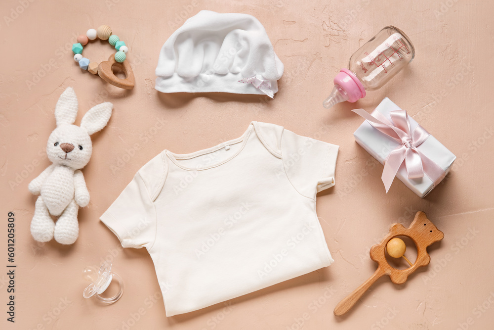 Composition with baby clothes, toys and accessories on beige background