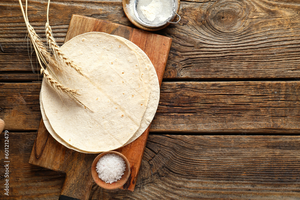 Board with fresh lavash on wooden background