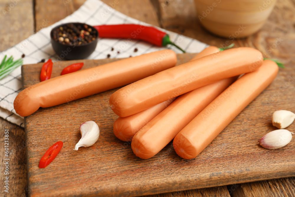 Board of tasty sausages with garlic and chilli on wooden background