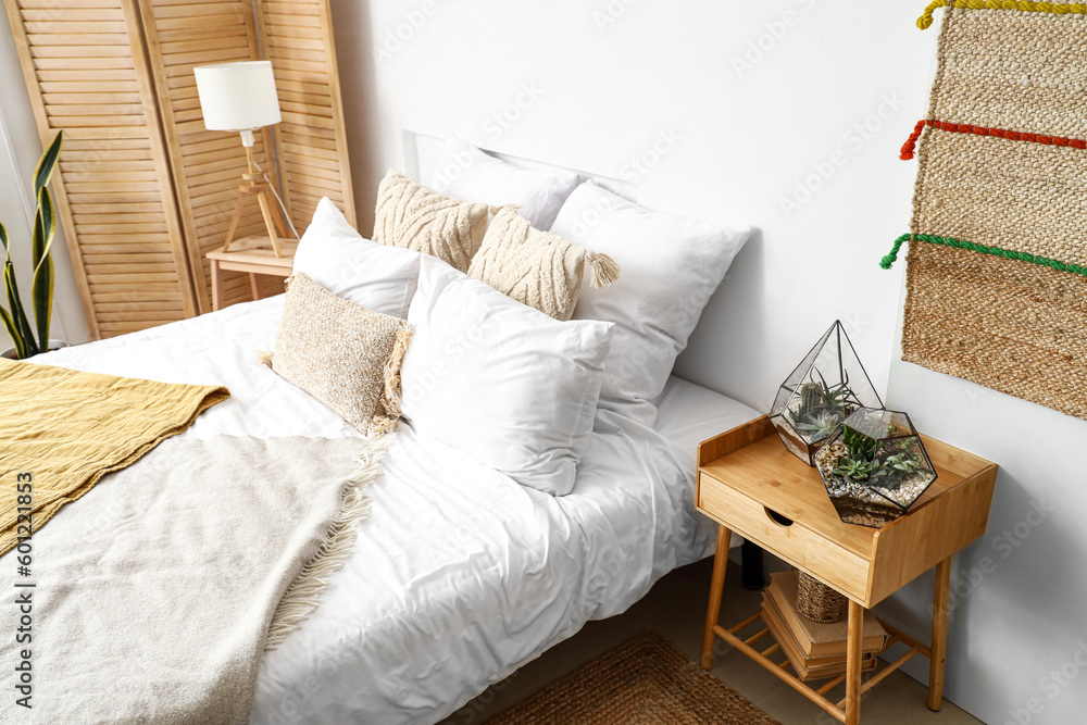 Florariums on table in interior of light bedroom