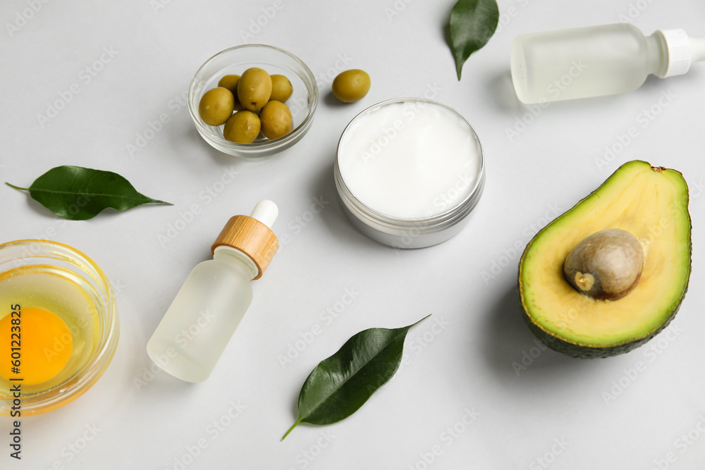 Composition with natural cosmetics, ingredients and plant leaves on light background