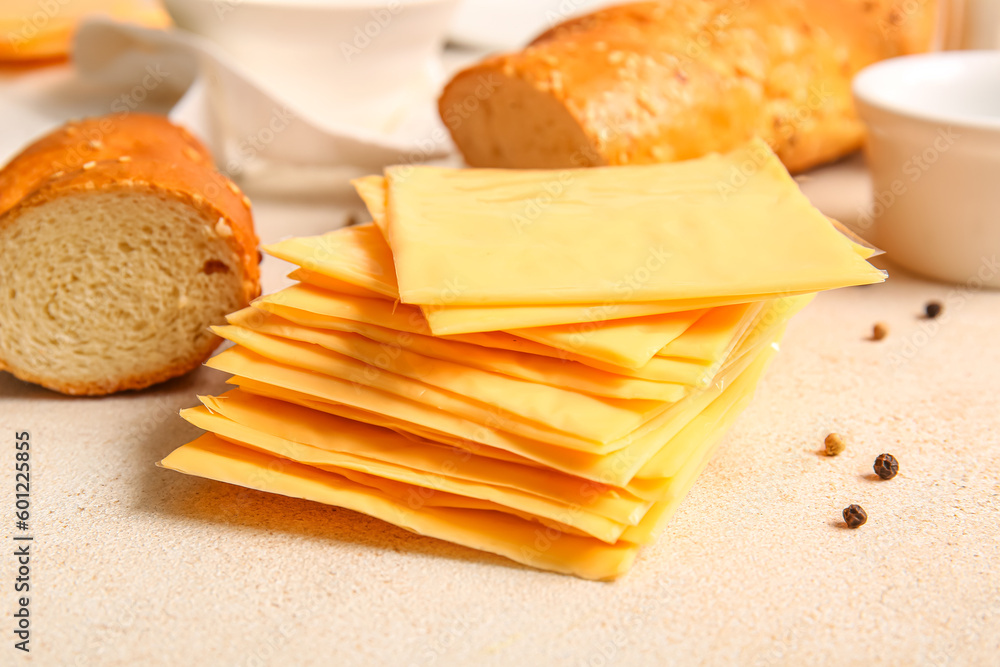 Slices of tasty processed cheese on light background