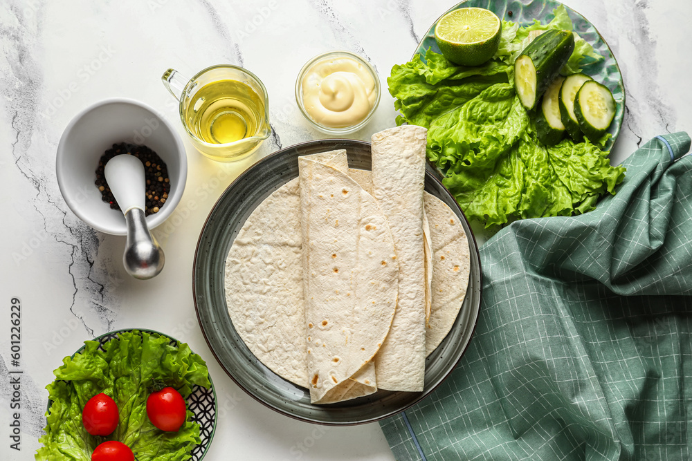 Plate with fresh lavash, oil, vegetables and sauce on white marble background