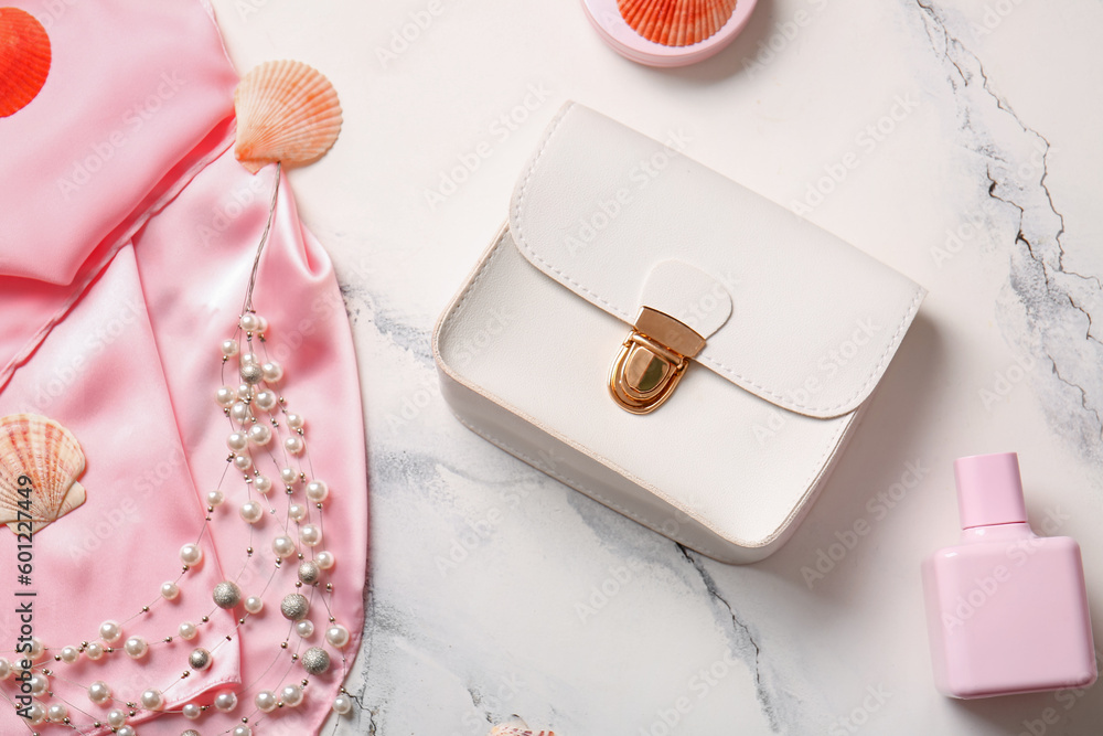 Stylish bag and perfume on white background