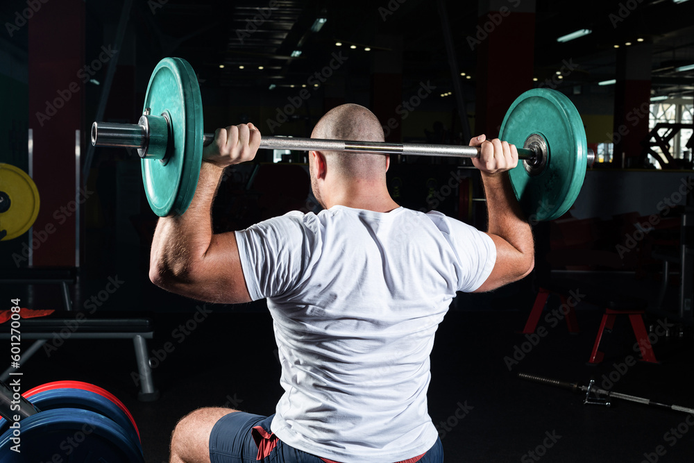 Male athlete lifts the barbell