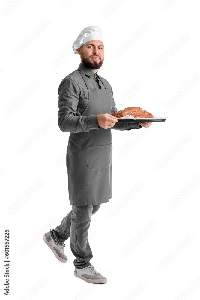 Male baker holding tray with rye bread on white background